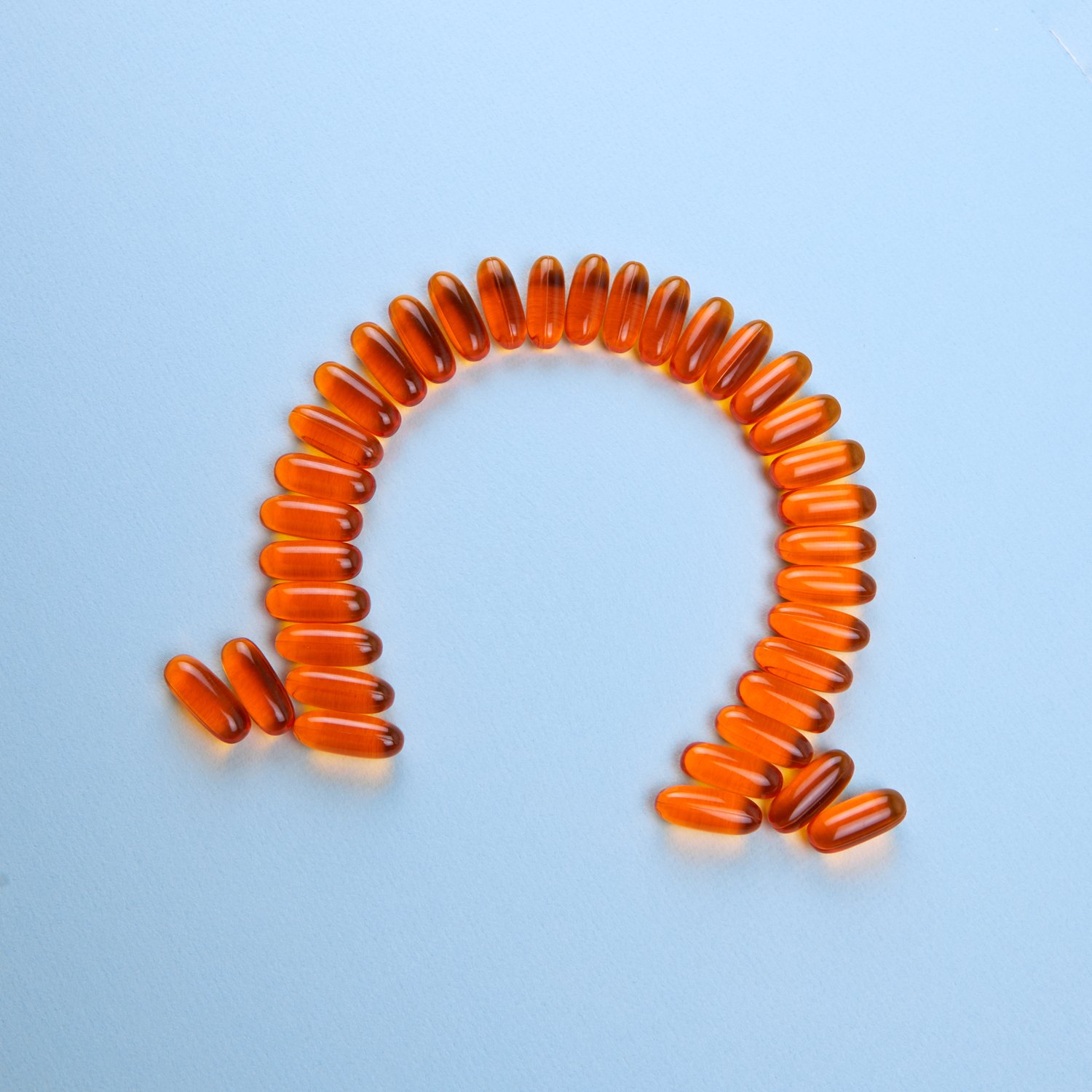 Omega-3 softgels arranged in an omega symbol