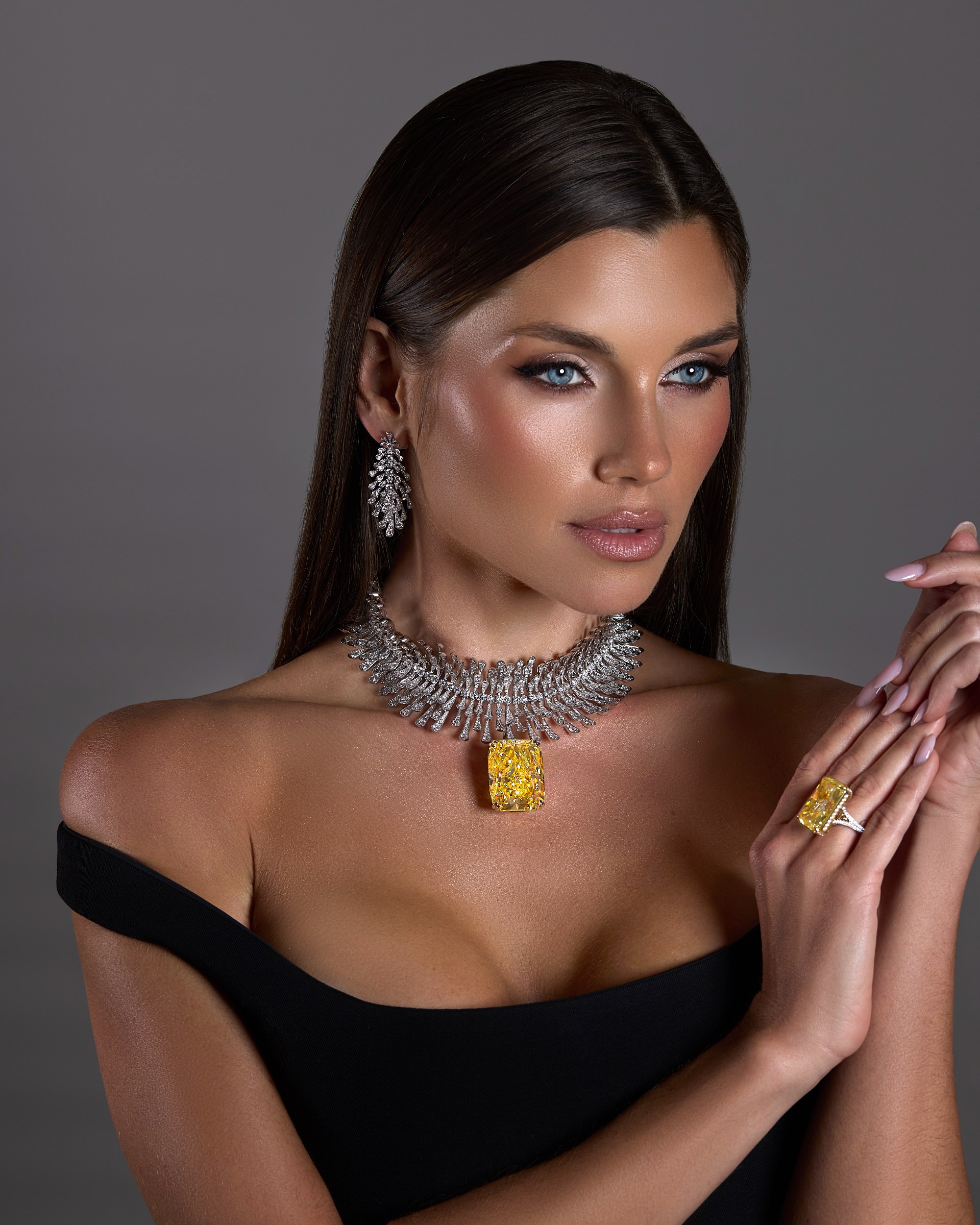 Yellow diamond pendant, ring and diamond earrings on model
